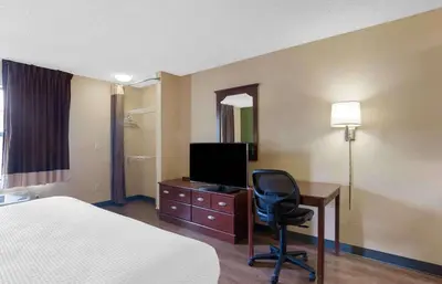 a hotel room with a bed and a desk with a television at Extended Stay America Suites - Los Angeles - Glendale in Glendale