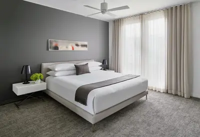 a bedroom with a white bed and a ceiling fan at AKA Beverly Hills in Los Angeles