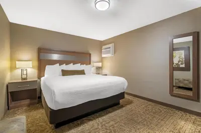 a hotel room with a large bed and a mirror at Best Western Plus Anaheim Inn in Anaheim
