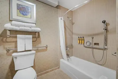 a bathroom with a shower and a toilet and a tub at Best Western Plus Anaheim Inn in Anaheim