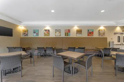 a dining room with tables and chairs and a tv at Best Western Plus Anaheim Inn in Anaheim