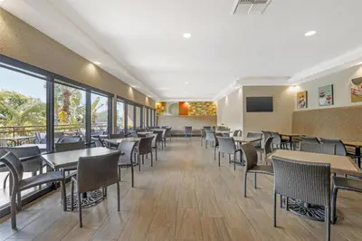 a dining room with tables and chairs and windows at Best Western Plus Anaheim Inn in Anaheim