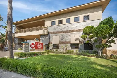 a building with a sign in front of a yard at Best Western Plus Anaheim Inn in Anaheim