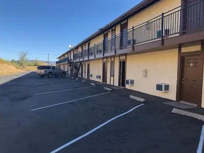 a car parked in a parking lot next to a building at Golden Hills Motel in Tehachapi