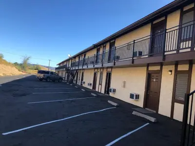 a car parked in a parking lot next to a building at Golden Hills Motel in Tehachapi