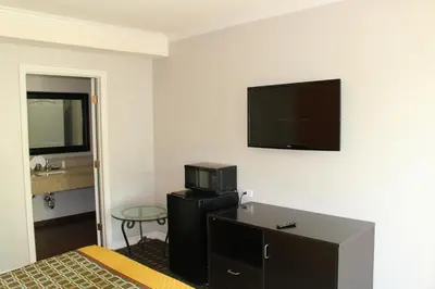 a hotel room with a bed and a flat screen tv at LYFE INN & SUITES by AGA - LAX Airport in Inglewood