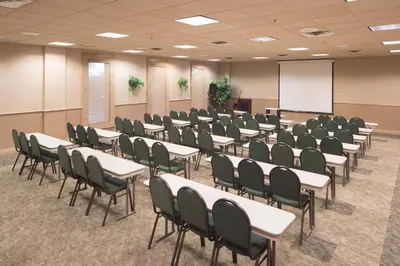 a conference room with tables and chairs and a whiteboard at New Gardena Hotel in Gardena