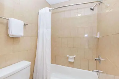 a bathroom with a shower with a tub and a toilet at Travelodge by Wyndham Sylmar CA in Sylmar
