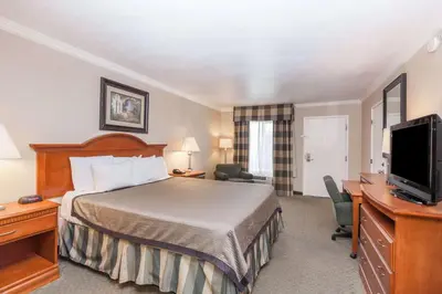 a hotel room with a bed and a flat screen tv at Travelodge by Wyndham Sylmar CA in Sylmar