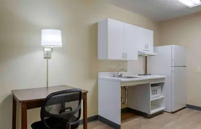 a small kitchen with a desk and a white refrigerator at Extended Stay America Suites - Los Angeles - Valencia in Stevenson Ranch