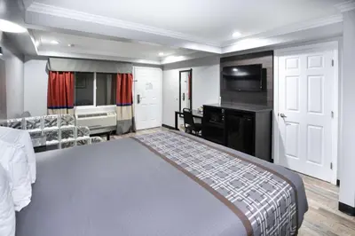 a bedroom with a bed and a desk and a television at Rodeway Inn & Suites Bellflower in Bellflower