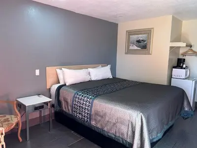 a small room with a bed and a small table at California Inn Hotel and Suites Adelanto US 395 in Adelanto