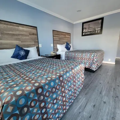 a hotel room with two beds and blue walls at Guest Harbor Inn- Port Of Los Angeles San Pedro in San Pedro