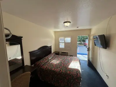 a hotel room with a bed and a television at Budget Inn Motel in South Gate