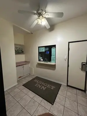 a living room with a ceiling fan and a window at Budget Inn Motel in South Gate