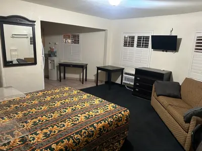 a hotel room with a bed and a couch at Budget Inn Motel in South Gate
