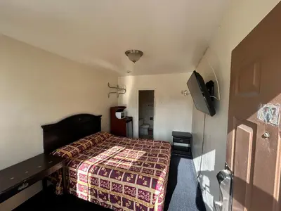 a hotel room with a bed and a television at Budget Inn Motel in South Gate