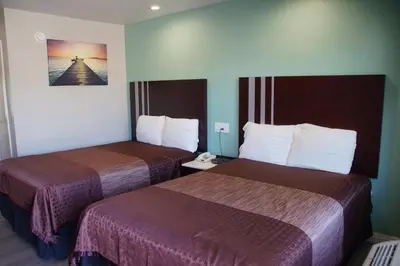 a hotel room with two beds and a phone at Beach Inn in Long Beach