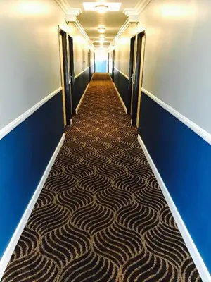 a long hallway with a carpeted floor in a building at Relax Inn in Los Angeles