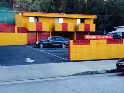 a car parked in a parking lot in front of a building at Relax Inn in Los Angeles