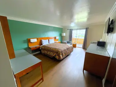 a hotel room with a bed and a desk at Relax Inn in Los Angeles