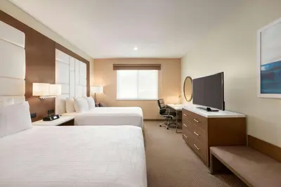 a hotel room with two beds and a flat screen tv at Wyndham Anaheim in Anaheim