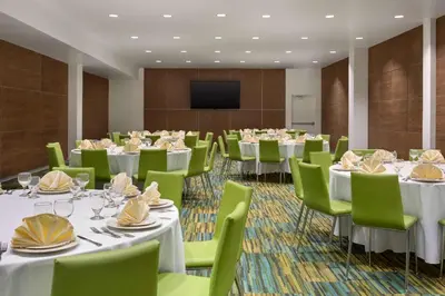a conference room with tables and chairs and a flat screen tv at Wyndham Anaheim in Anaheim