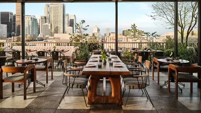 a restaurant with tables and chairs and a view of the city at Downtown Los Angeles Proper Hotel, a Member of Design Hotels in Los Angeles