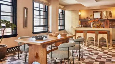 a kitchen with a wooden table and chairs at Downtown Los Angeles Proper Hotel, a Member of Design Hotels in Los Angeles