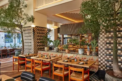 a restaurant with wooden tables and chairs at Downtown Los Angeles Proper Hotel, a Member of Design Hotels in Los Angeles