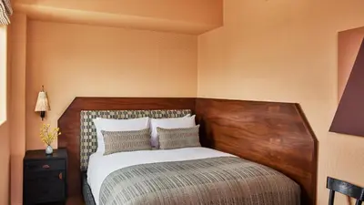 a bedroom with a bed with a wooden head board at Downtown Los Angeles Proper Hotel, a Member of Design Hotels in Los Angeles