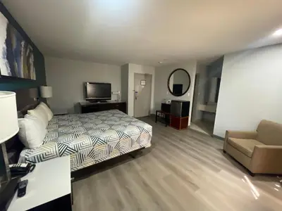 a bedroom with a bed and a couch and a television at Portside Inn & suites in San Pedro