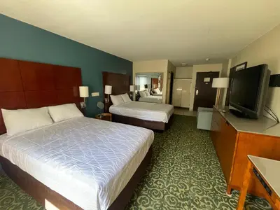 a hotel room with two beds and a flat screen tv at Portside Inn & suites in San Pedro