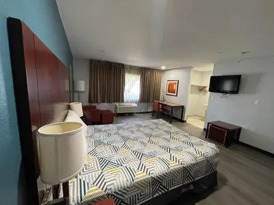 a hotel room with a bed and a living room at Portside Inn & suites in San Pedro