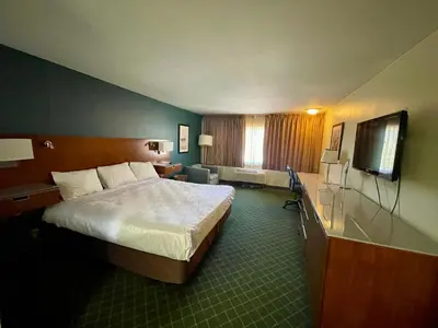a hotel room with a bed and a flat screen tv at Portside Inn & suites in San Pedro