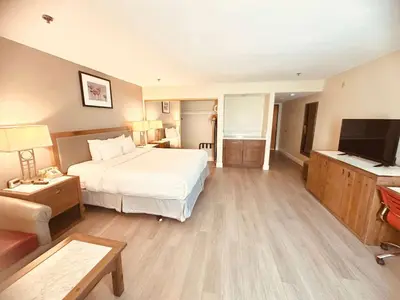 a hotel room with a bed and a flat screen tv at Ramada Plaza by Wyndham Garden Grove/Anaheim South in Anaheim