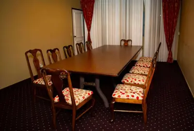 a dining room table with four chairs and a wooden table and chairs at Ramada Plaza by Wyndham Garden Grove/Anaheim South in Anaheim