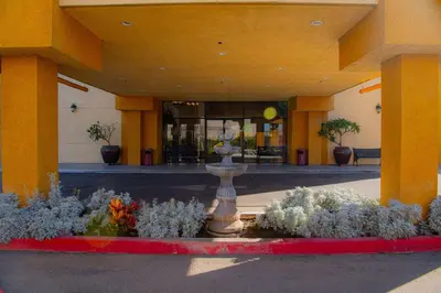 a building with a fountain in front of a building at Ramada Plaza by Wyndham Garden Grove/Anaheim South in Anaheim