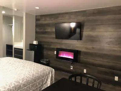 a bedroom with a bed and a flat screen tv on a wall at Sakura Inn in Glendale