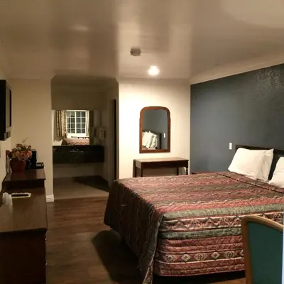 a hotel room with a bed and a mirror at Royal Inn in Lomita