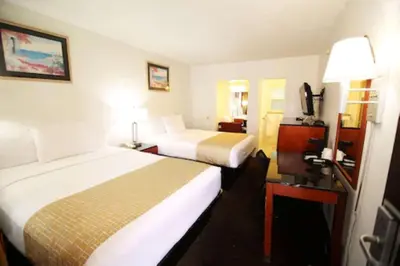 a hotel room with two beds and a lamp at Travelodge by Wyndham Burbank-Glendale in Burbank
