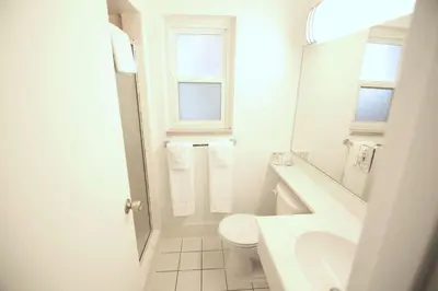 a white bathroom with a sink and a toilet at Travelodge by Wyndham Burbank-Glendale in Burbank