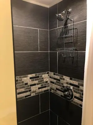 a bathroom with a black tiled shower at VacaStay on Scandia Way in Los Angeles