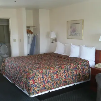 a hotel room with a large bed with a colorful bedspread at Days Inn by Wyndham Orange Anaheim in Orange