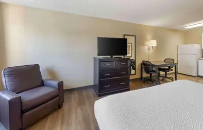 a hotel room with a bed and a tv and a chair at Extended Stay America Suites - Bakersfield - California Avenue in Bakersfield