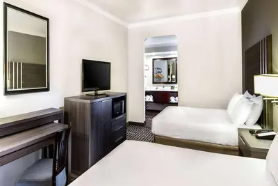 a hotel room with a bed and a flat screen tv at Travelodge by Wyndham Commerce Los Angeles Area in Commerce