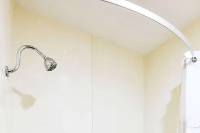 a shower in a bathroom with a shower head at Travelodge by Wyndham Commerce Los Angeles Area in Commerce