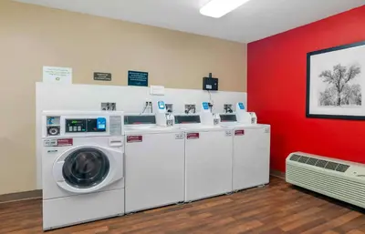 a room with three washing machines and a red wall at Extended Stay America Suites - Los Angeles - Torrance Harborgate Way in Carson