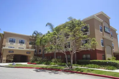 an apartment building with a tree in front of it at Extended Stay America Suites - Los Angeles - Torrance Harborgate Way in Carson