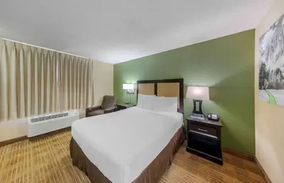 a hotel room with a large bed and a chair at Extended Stay America Suites - Los Angeles - Arcadia in Arcadia